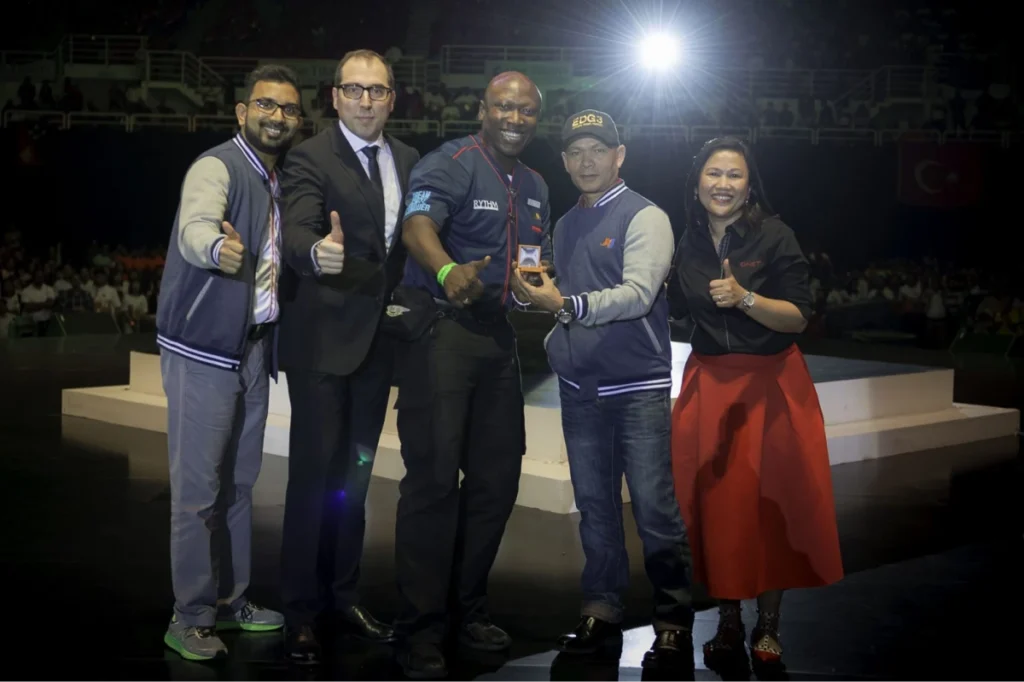 Global Entrepreneurship Month: Qnet Success Stories To Inspire 4 Fofana Amaral on stage with JR Mayer, Chief Pathman, and Mr.Bismark
