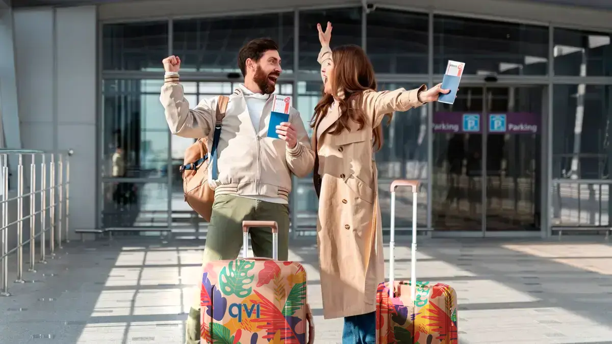 The Real Reason Everyone’s Choosing Package Holidays In 2025 2 Couple excited to escape winter season by going on a budget-friendly package holiday, which they booked through QVI Vacay