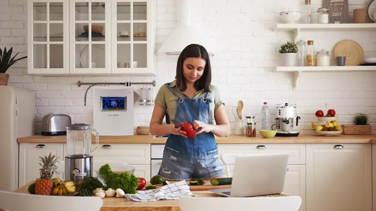 Homepure Viva: Championing Your Biggest Resolutions For A Remarkable New Year 3 Young woman in the kitchen cutting vegetables which she prepared with the help of HomePure Viva water