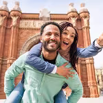 Man giving woman a piggy back ride in Europe while on a trip booked through a QVI holiday membership