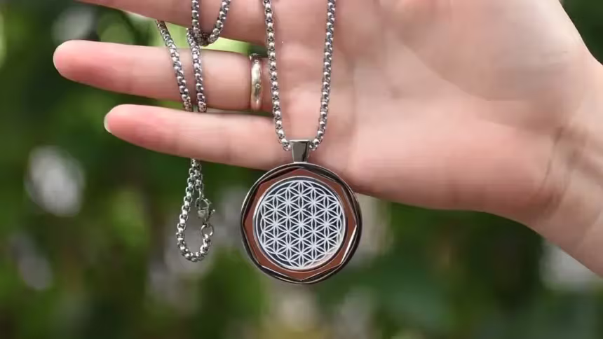 A hand of a person hold a Amezcua Chi Pendant 4. One of the QNET wellness product which would be one of the gift idea.